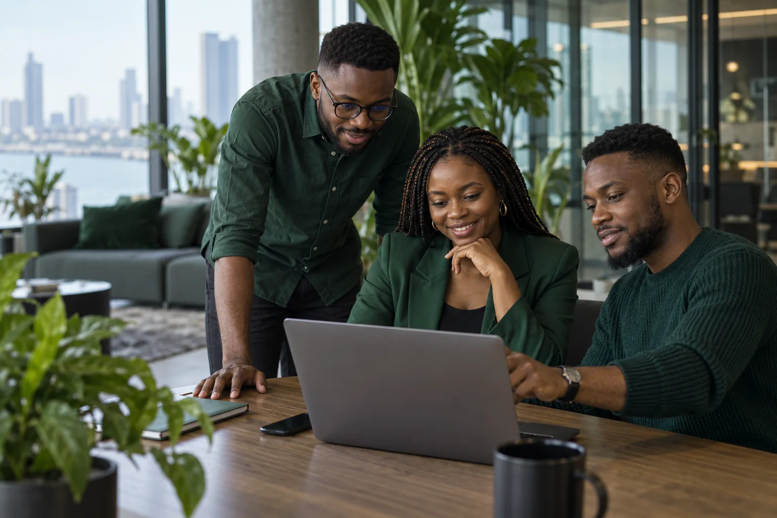 Technology professionals collaborating around a laptop